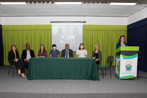 Fotografia da mesa de honra e da juíza Ana Freitas falando no púlpito