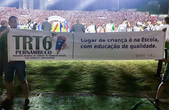Garotos seguram faixa no estádio