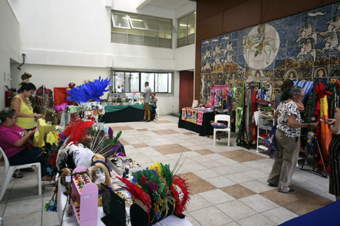 Exposição com diversos produtos artesanais e pessoas vendendo e comprando