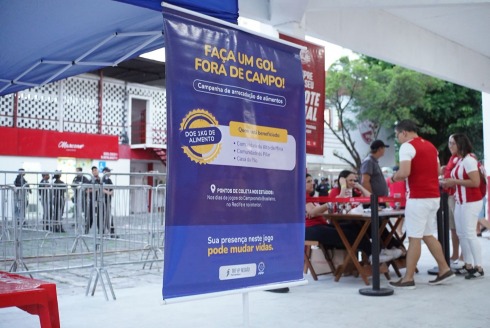 Banner de campanha de alimentos na entrada do estádio dos Aflitos