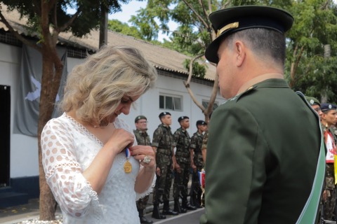 Fotografia de uma autoridade civil recebendo medalha de um militar