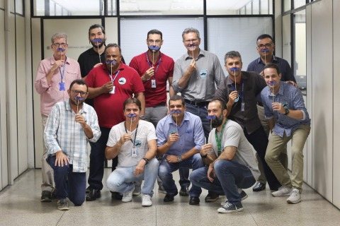 Fotografia com homens posando, cada um com um bigode de papel azul