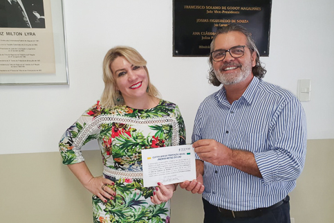 Fotografia da juíza Renata Lapenda e do diretor Hélio Donato segurando um certificado