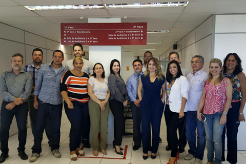 Grupo de 15 pessoas dentro de uma sala, posando para foto
