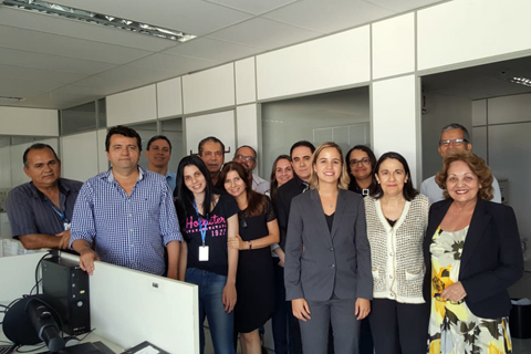 Grupo de 14 pessoas dentro de uma sala, posando para foto
