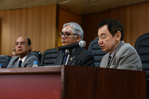 Foto parcial da mesa de honra. Autoridade discursando.