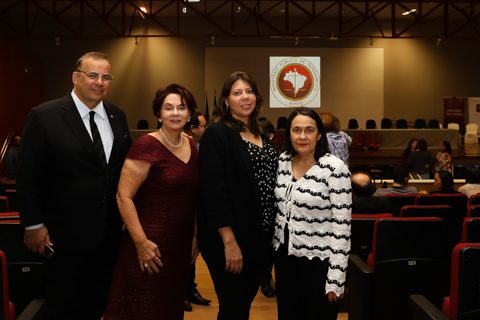 Fotografia de quatro pessoas dentro de um auditório