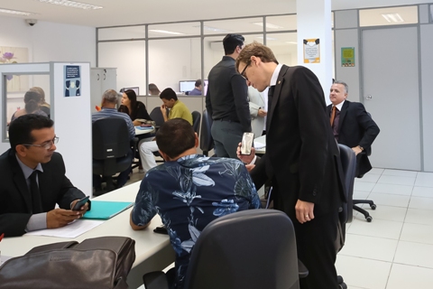 Fotografia de vários grupos de pessoas sentados a mesa de negociações dentro do Cejusc Recife