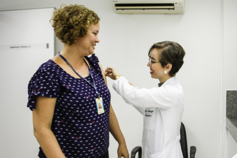 Fotografia de uma enfermeira vacinando uma mulher