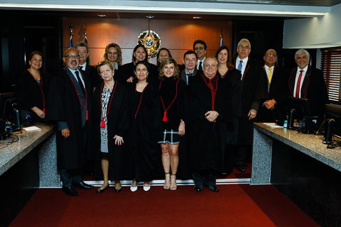 Fotografia de 15 autoridades vestindo toga. Atrás é possível ver o Brasão da República