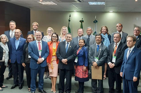 Foto dos ouvidores na frente do auditório onde aconteceu o evento