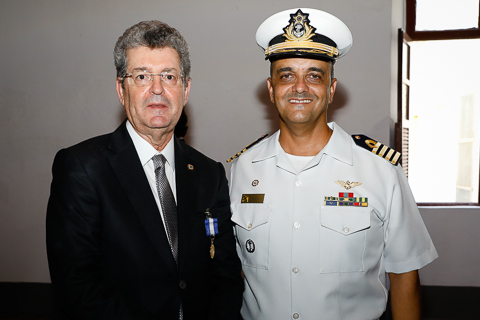 Fotografia de dois homens lado a lado. Um usa terno e o outro a farda da Marinha