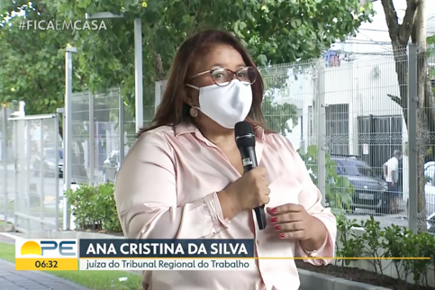 Fotografia da juíza Ana Cristina falando ao microfone. Ela usa máscara 