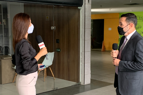 Foto da repórter e do juiz, ambos com microfone na mão