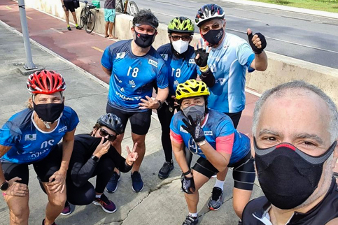 Integrantes do Grude6 com equipamentos de ciclismo ao lado da ciclovia da Via Mangue
