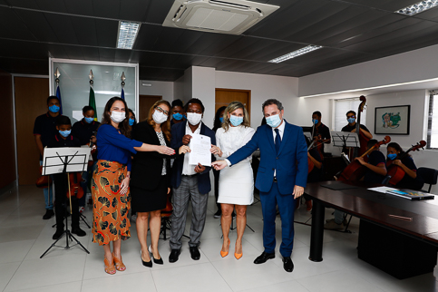 Representantes das instituições envolvidas no acordo posam para foto com o contrato na mão.