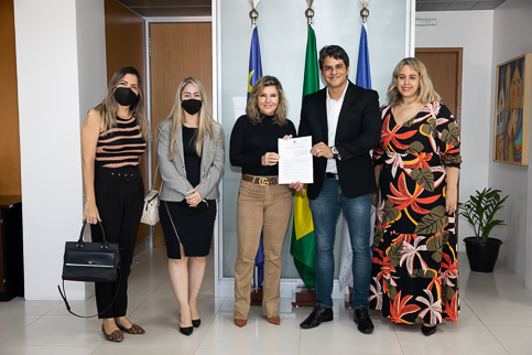 Foto dos participantes da reunião em pé posando para a foto