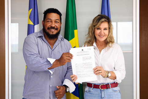 Foto da presidente e do coordenador posando com o termo de doação nas mãos