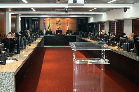 Foto da sessão do Pleno. Desembargadores estão em uma mesa em formato de U, cada um utiliza um computador