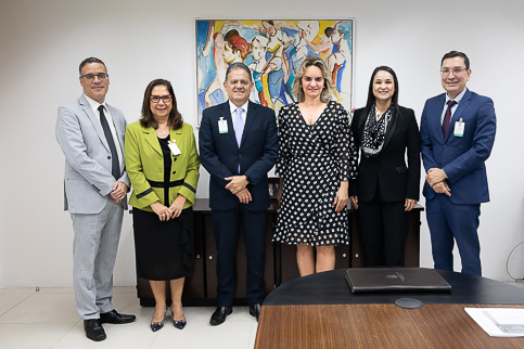 retrato de seis pessoas com trajes formais. Elas estão em pé e olhando para a câmera