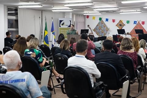 Foto do palestrante em frente ao púlpito falando para os presentes