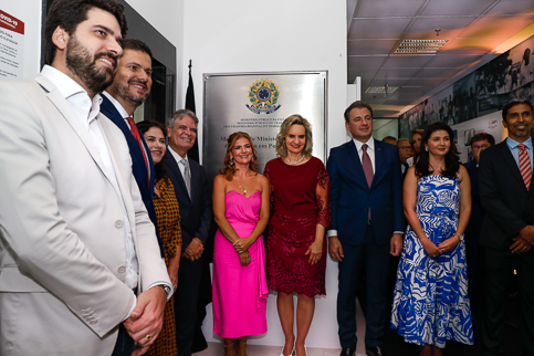 Foto de participantes do evento posando ao lado da placa de inauguração