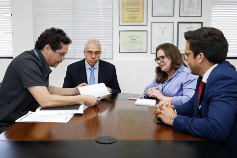 Foto dos participantes do encontro ao redor da mesa de reunião