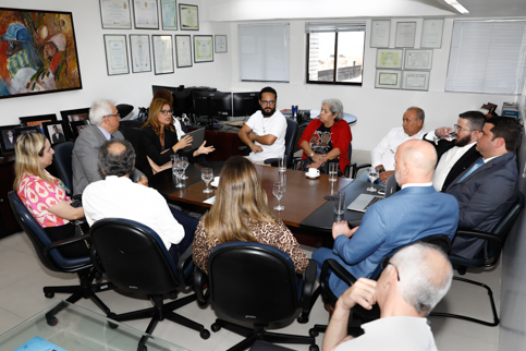 Foto dos participantes do encontro na mesa de reunião