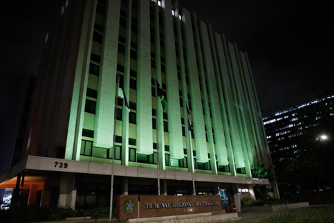 Prédio-sede do TRT-6 iluminado com reflexo de luz verde 