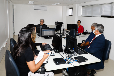 foto sala de audiência com seis pessoas sentadas 