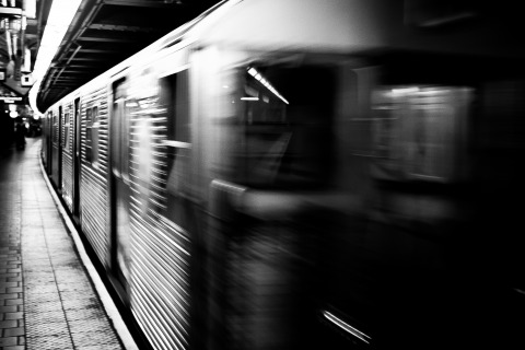 Foto preta e branca mostra um vagão de metrô em movimento
