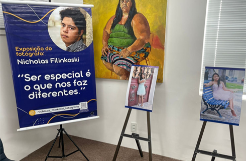 Foto de duas das fotografias exposta ao lado do banner da exposição