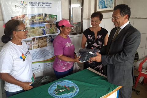 Fotografia do servidor Remígio fazendo entrega de EPIs a trabalhadores da associação de catadores Nova Vida