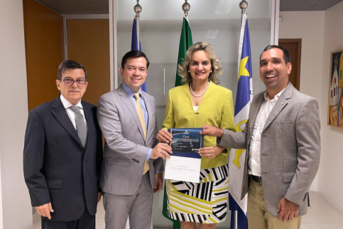 foto de quatro autoridades. Uma delas, a presidente do TRT-6, desa. Nise Pedroso segura um convite