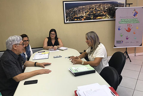 Fotografia de pessoas em sentadas a mesa de reuniões