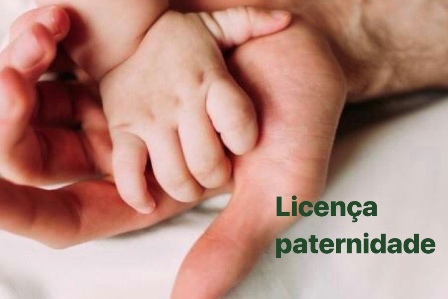 Foto mostra mão de bebê em cima de uma mão masculina e o texto Licença paternidade