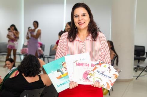 Foto da juíza Mariana Milet com os livros do projeto 