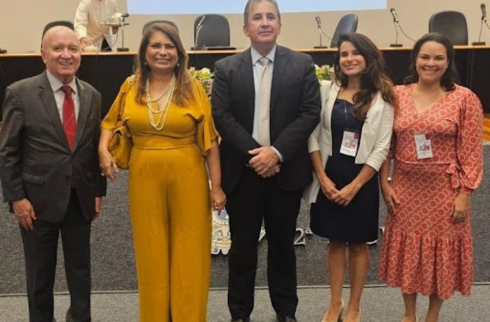 Foto da juíza ao lado de mais participantes do evento
