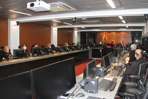 Fotografia da sessão do Pleno. Desembargadores estão em uma mesa em formato de U e cada um utiliza um computador