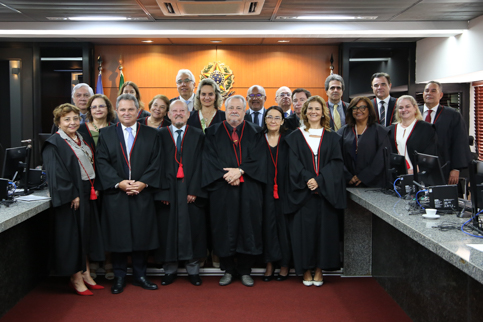 fotografia de várias pessoas de toga, em pé, sorrindo e olhando para a câmera. 
