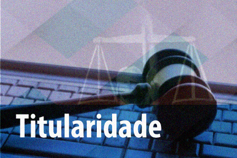 Martelo de juiz apoiado em cima da mesa. Na frente da imagem há o texto &quot;titularidade&quot;