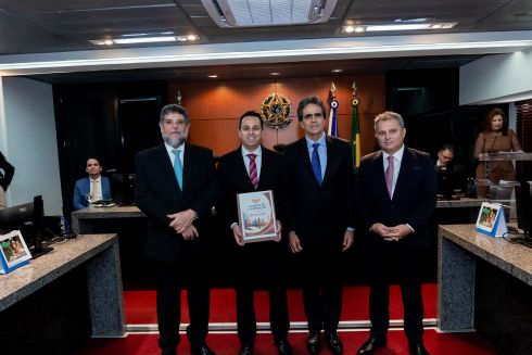 foto quatro pessoas em pé segurando documento de acordo