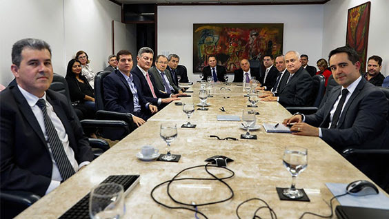 Foto dos participantes da reunião sentados à mesa no auditório do TRF5