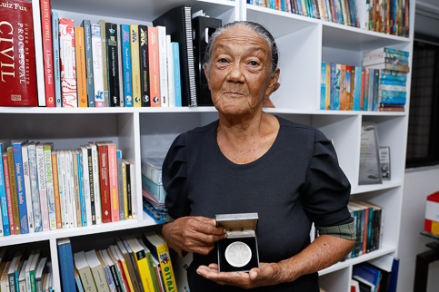 foto de Pureza Lopes segurando a medalha do Anti-Slavery International