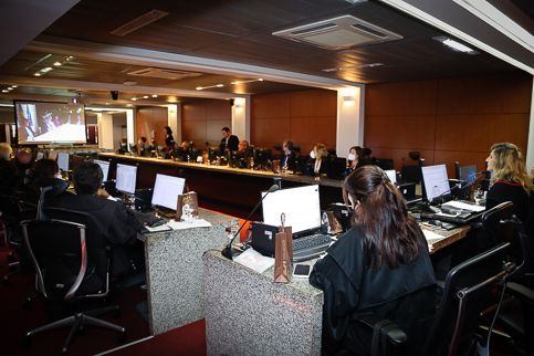 Foto dos desembargadores assistindo a um vídeo transmito no telão da sala de sessões do Pleno
