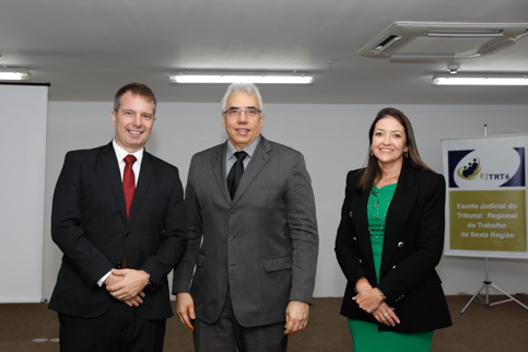 retrato de três pessoas usando terno e dentro de um auditório