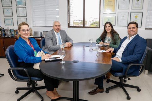 Desembargador Sergio Torres, servidor e servidora sentados à mesa.