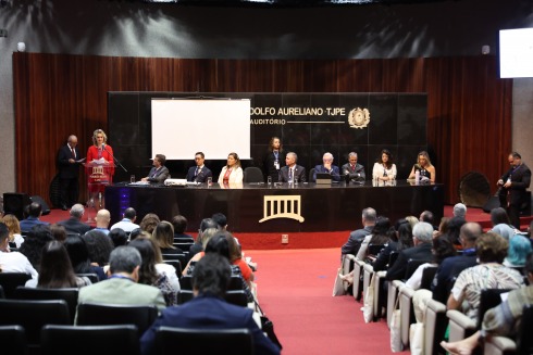 fotografia de pessoas em um auditório. A presidente Nise Pedroso fala ao púlpito