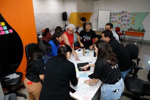 foto de várias pessoas trabalhando em volta de uma mesa