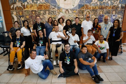 Fotografia de um grupo de pessoas. Algumas estão em cadeira de rodas